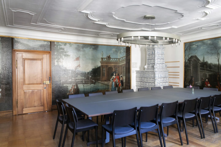 In der Ecke des Barockzimmers gibt es einen Kachelofen. Der grosse Tisch bietet Platz für bis zu 18 Personen.